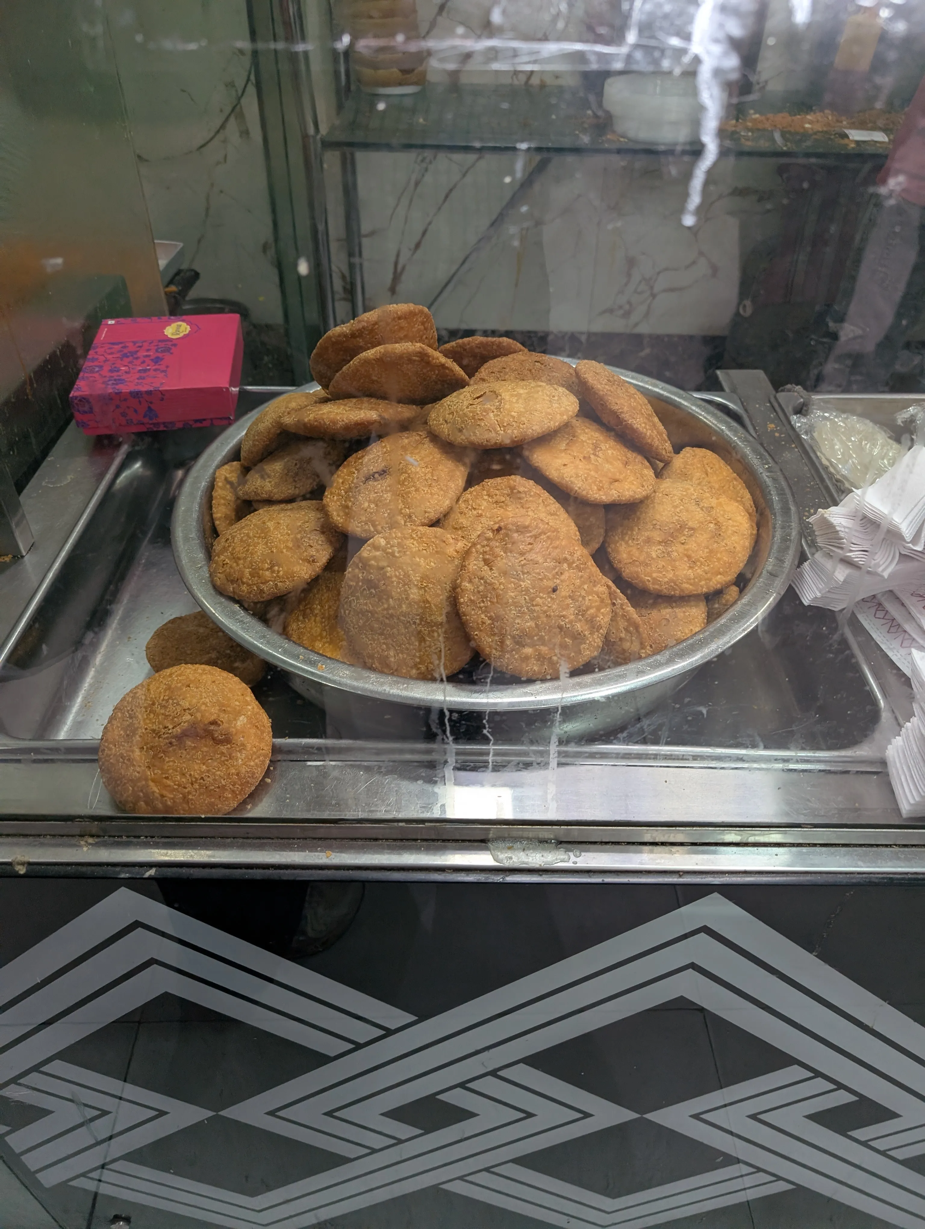 A pile of aloo kachori at a street stall — fried bread stuffed with spiced potato.