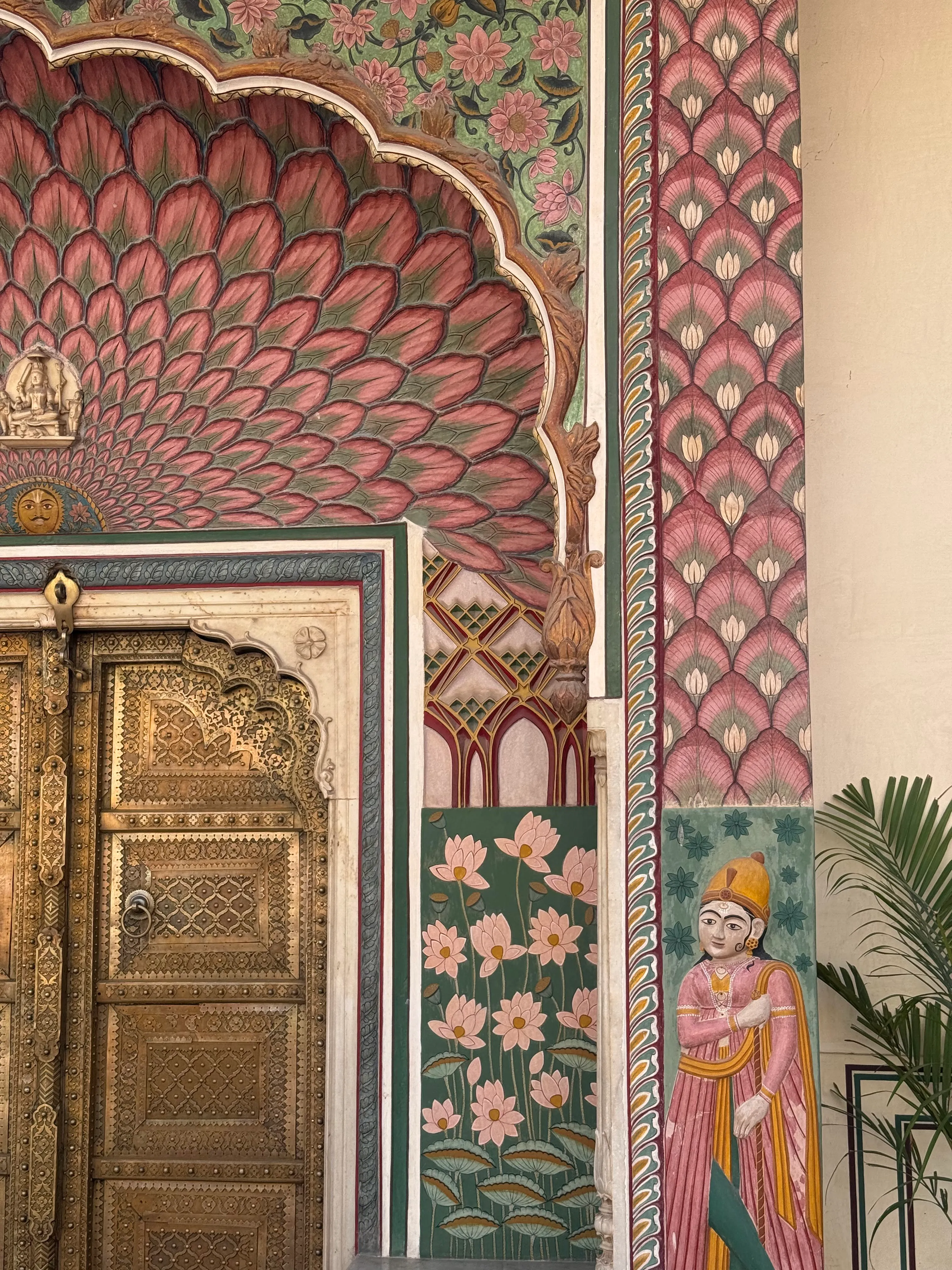 The Lotus Gate at Jaipur's City Palace, painted in pink lotus motifs with a maharaja figure on the wall.