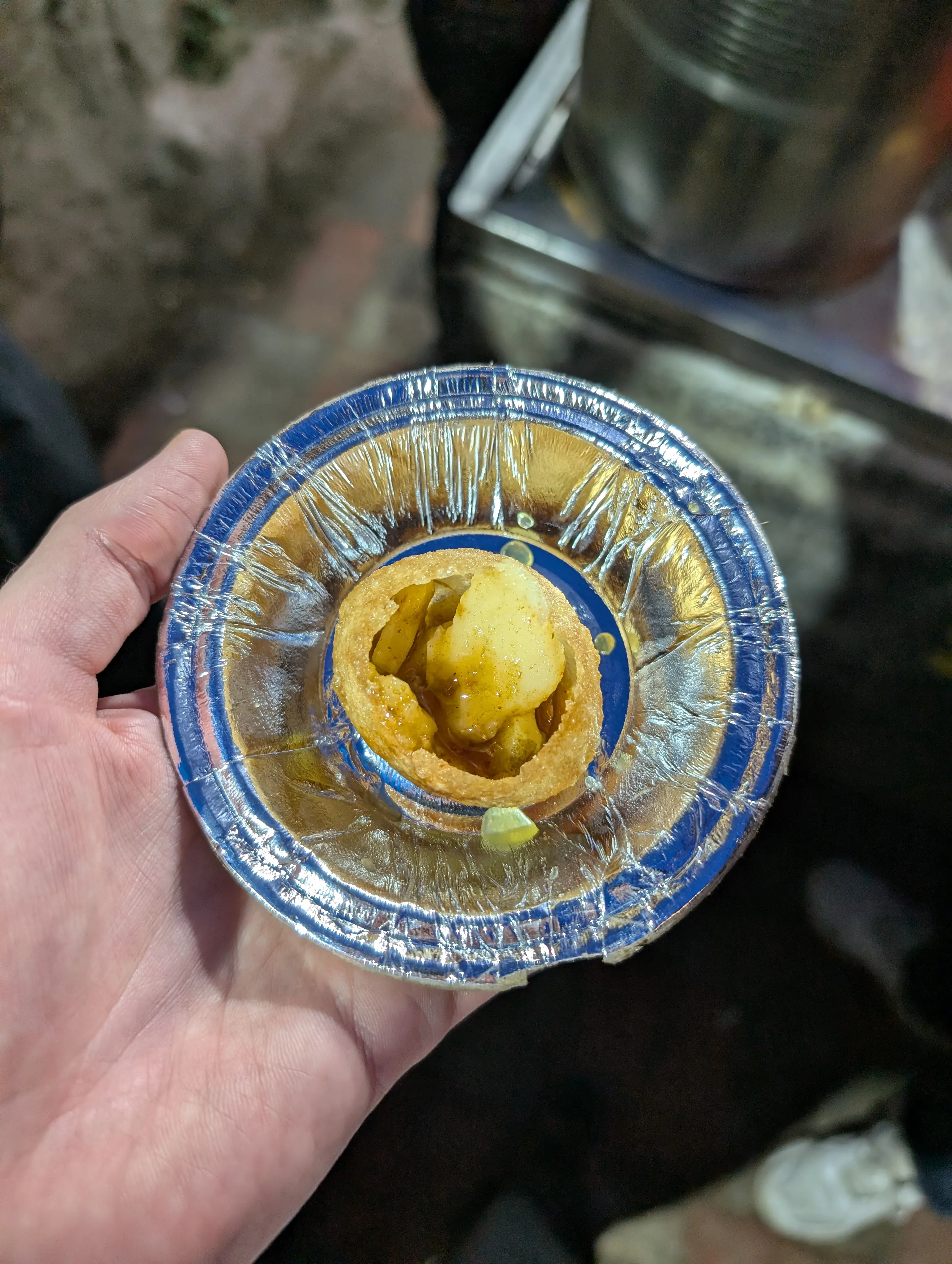 Pani puri: a hollow fried crisp filled with spiced water and potato, eaten in one bite.